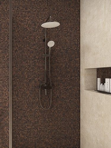 Moderne dusj med mørk mosaikk på veggen og innebygd hylle